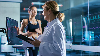 Frau an Monitor beim Fitness-Check