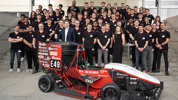 Gruppenfoto von High Voltage mit Rennwagen