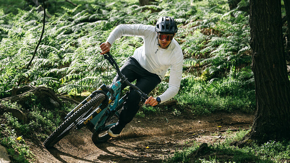Mann auf dem E-Mountainbike von Yeti in einer Kurve im Wald