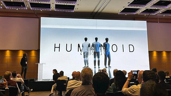 Drei Humanoide auf einer Bühne