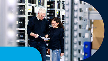 Two people in the warehouse check a list