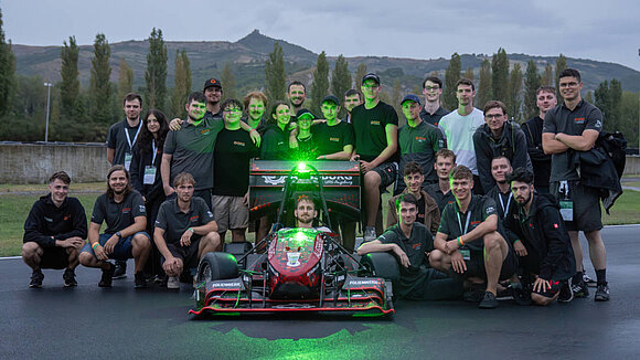 Group photo of Starkstrom Augsburg with their racing car