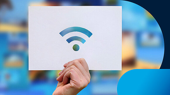 A hand is holding a poster with the Wi-Fi symbol