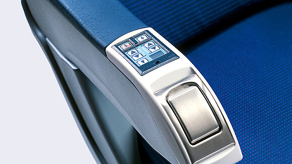 Close-up of an airplane armrest with a display