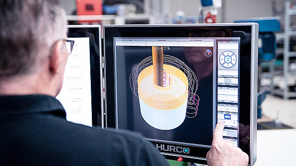 A man constructs something on a PC screen