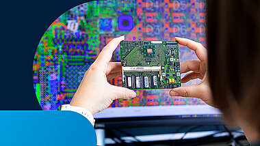 Person holds an embedded module in both in front of a PC screen