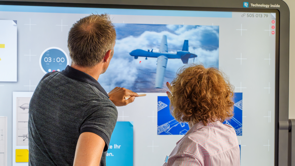 Rückenansicht von zwei Personen vor einem cannyboard