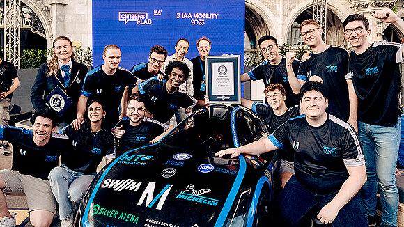 Group photo of the TU Fast Team with an electric race car