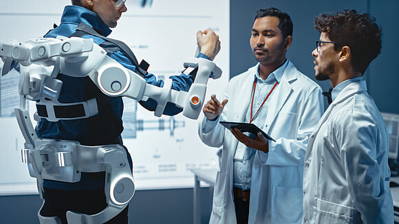 Two doctors test an exoskeleton on a person