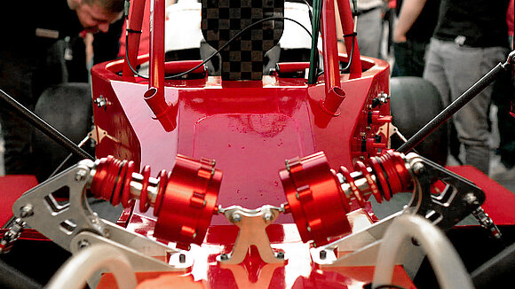 Close-up of the undercarriage of a red electric race car