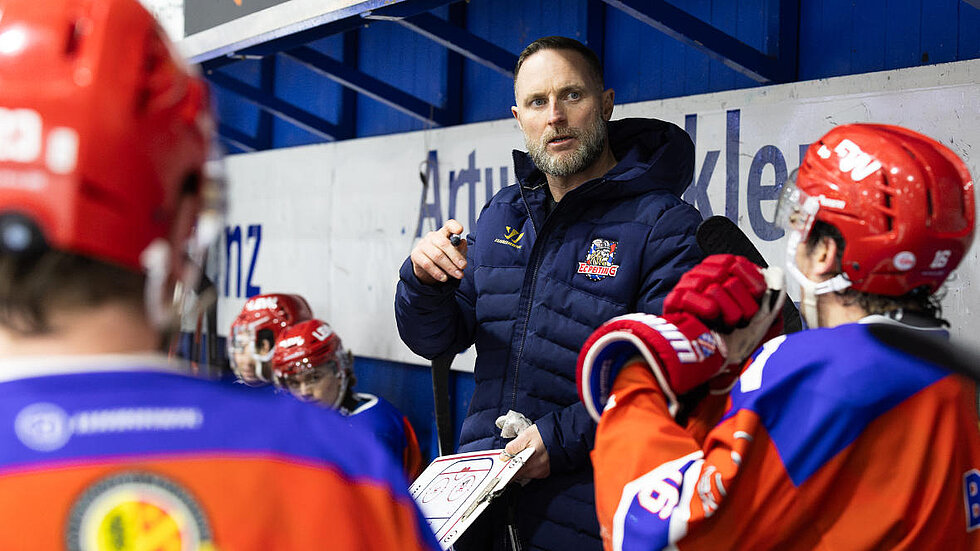 Trainer erklärt Eishockey Spielern etwas
