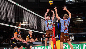 Zwei Volleyballspieler springen hoch am Netz