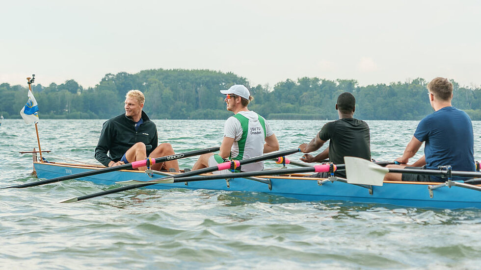 Oliver Zeidler beim Rudertraining mit 3 Personen im Boot