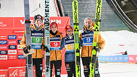 Vier deutsche Skispringer mit ihren Skiern in der Hand