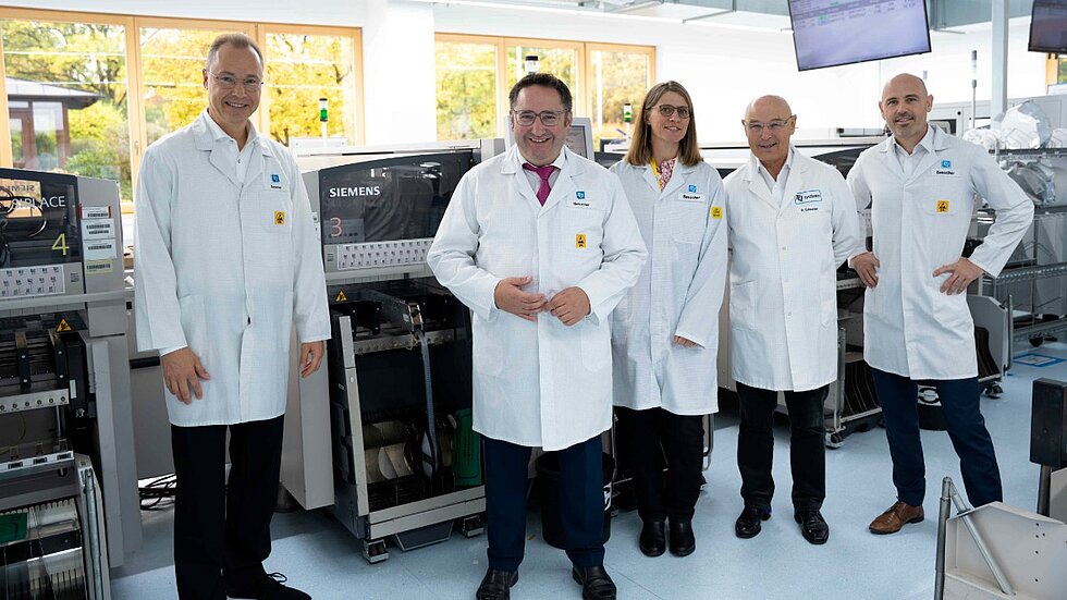 Group photo from the production floor featuring Rüdiger Stahl, Tobias Gotthardt, Anne Köster, Detlef Schneider, and Stefan Schneider