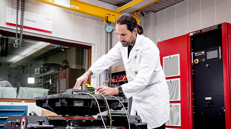 An employee is testing something on a vibrating table