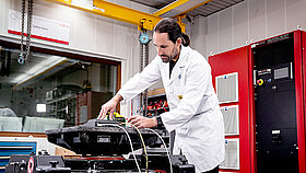 An employee is testing something on a vibrating table