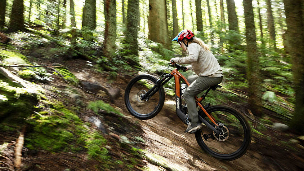 Frau auf Trek E-Mountainbike berauf im Wald