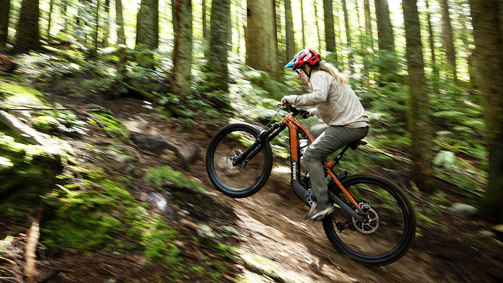 Frau auf Trek E-Mountainbike berauf im Wald