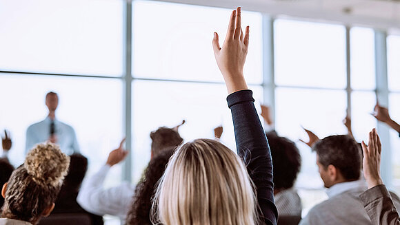 Woman raises arm to question