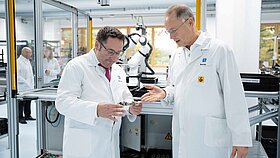 Rüdiger Stahl from TQ shows Tobias Gotthardt an electronic component on the production line