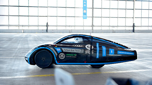 Black-and-blue electric race car, viewed from the side