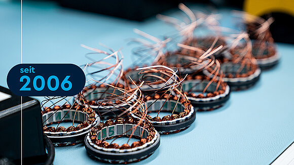 Frameless motors on a production table with copper wires bearing the year 2006