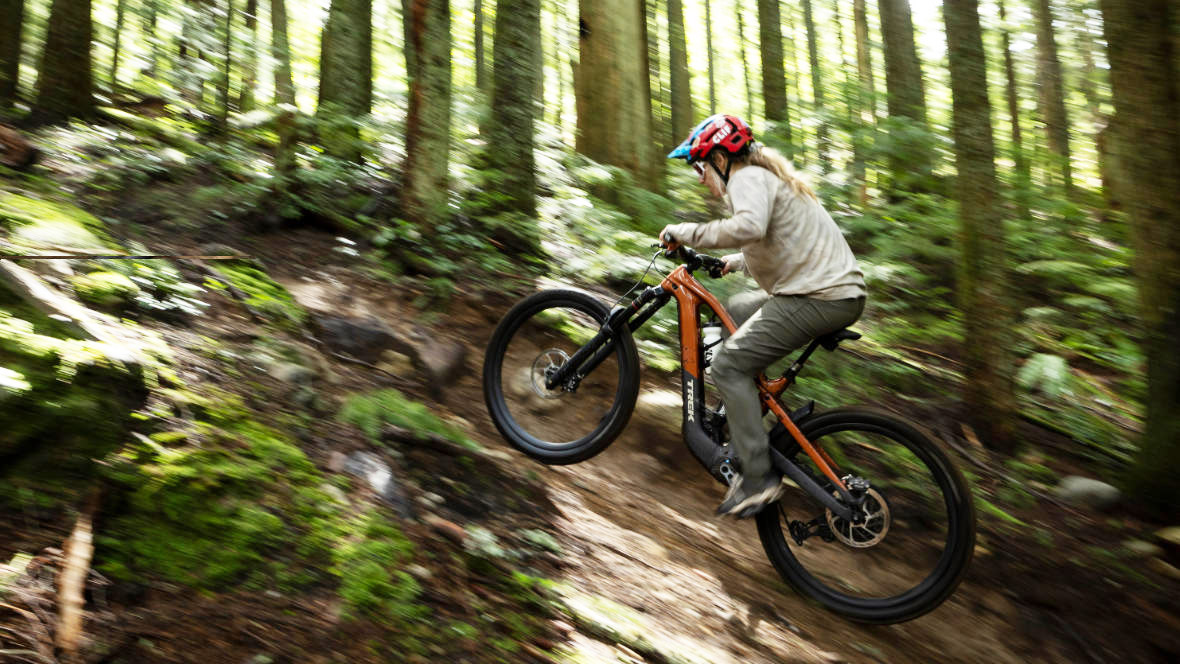 Frau auf Trek E-Mountainbike berauf im Wald