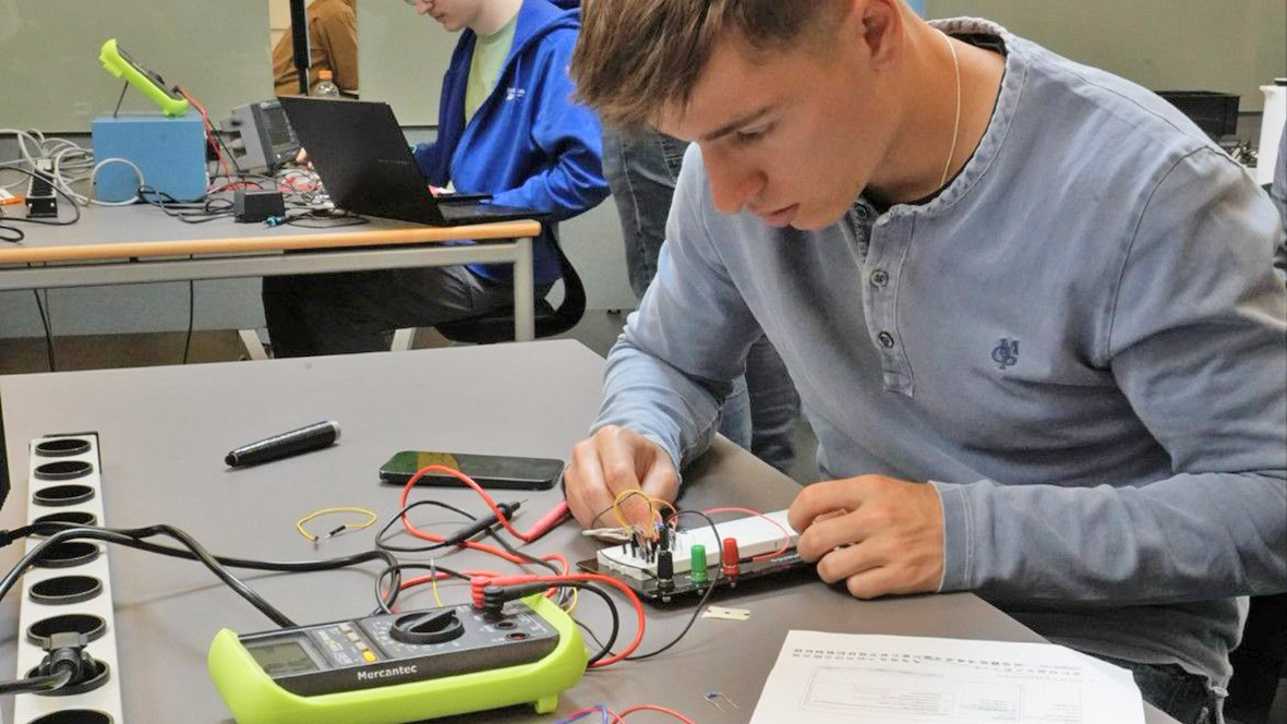 Azubi vom Erasmus Austausch prüft ein elektronisches Gerät