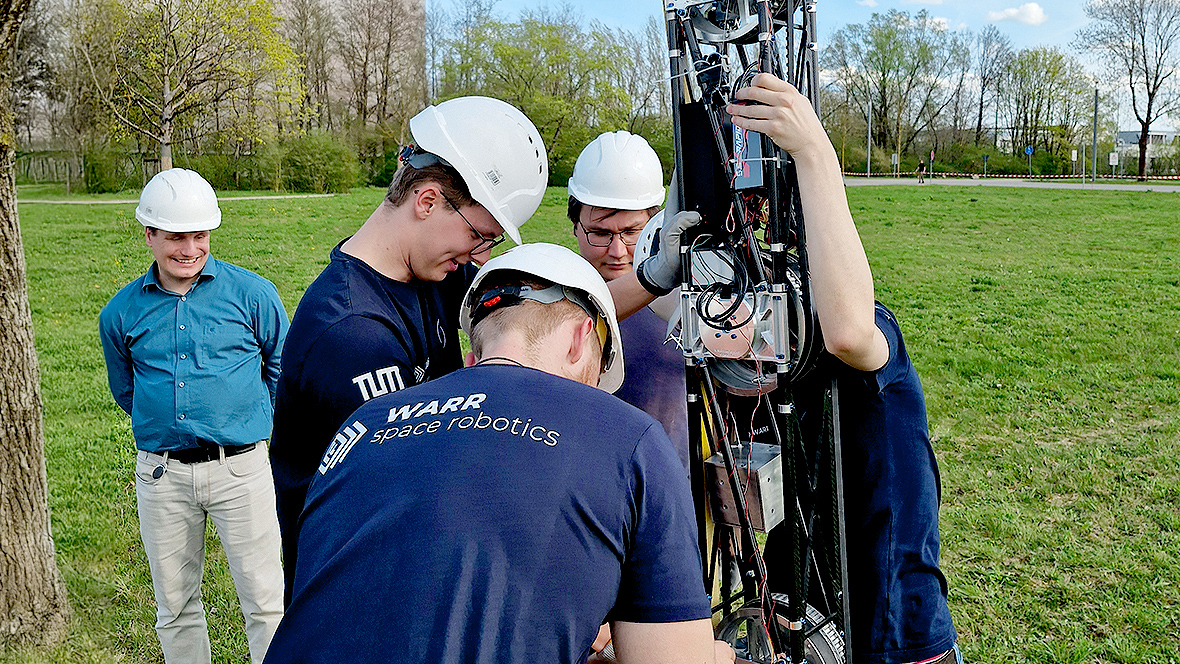 Members of the WARR Space Robotics Team are assembling and testing a technical robotics system outdoors