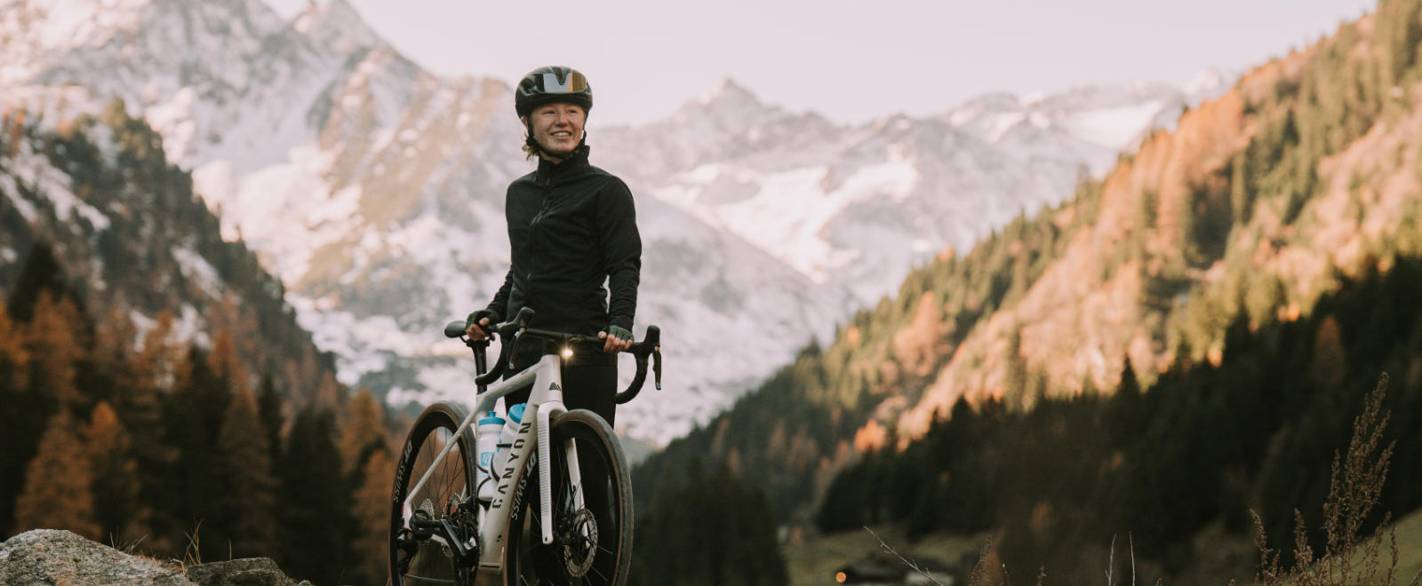 Athletin Muriel Mohr mit einem Canyon E-Roadbike im Hintergrund Berge
